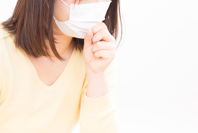 咳き込むマスクをした女性